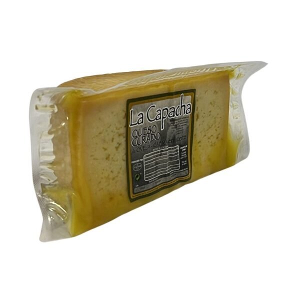 Corte de queso curado mezcla oveja y cabra La Capacha pasta marfil ojos mecánicos afinado en aceite oliva